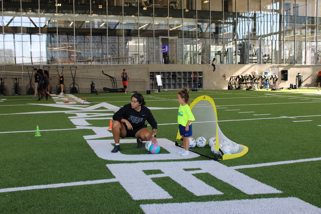 Coach and young player training indoors